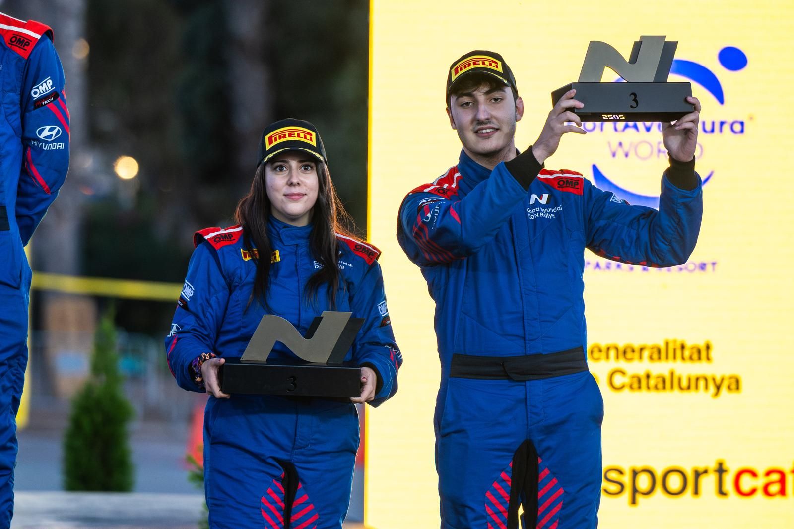 Alejandro Medín y su copiloto con el trofeo de la Copa Hyundai i20N en el podio del RallyRACC Catalunya